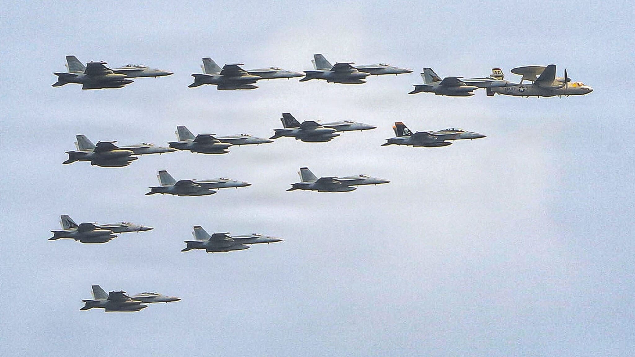 Jets der US-Navy fliegen als Eskorte und Begleitschutz in einer engen Formation mit einem ...