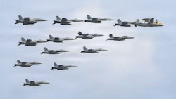 Jets der US-Navy fliegen als Eskorte und Begleitschutz in einer engen Formation mit einem ...