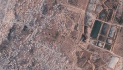 Auf den Satellitenbildern ist der Erdwall deutlich zu sehen, der die Zeltstädte von jenem ...