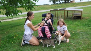 Das Mädchen (im Bild mit zwei ihrer Schwestern) ist trotz ihrer schweren Beeinträchtigung meist ...