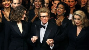 AFP/APA-Images / AFP / JEAN-PIERRE MULLER Mit dem Smoking für Frauen schrieb Yves Saint Laurent – hier umringt von Stars wie Catherine ...