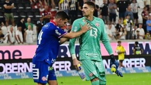 Die Szene nach dem Wurf-Eklat: Peter Michorl muss seinen Goalie Cican Stanković davon abhalten, ...