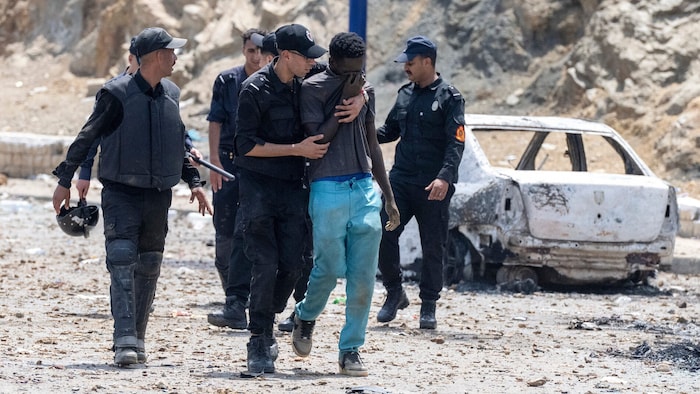 Marokkanische Polizisten bei der Verhaftung eines Migranten