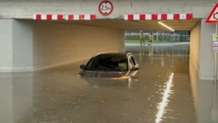 Land unter in Kundl. Bei einer überfluteten Bahnunterführung blieb ein Fahrzeug stecken, die ...