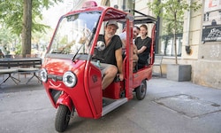 Mit einem Elektro-Dreirad wie diesem werden Fahrgäste durch Graz kutschiert.
