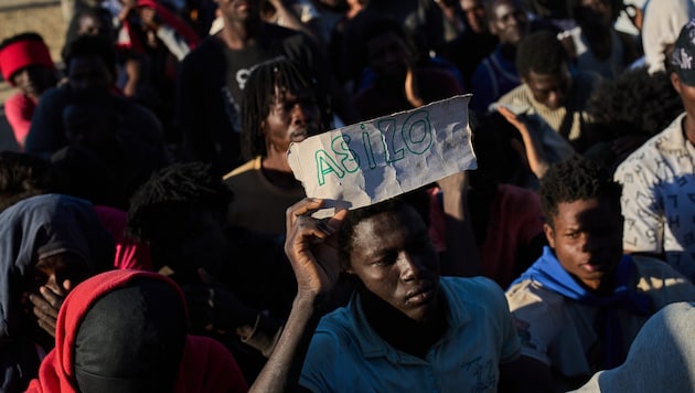 Ein Migrant hält nach dem Ansturm auf Ceuta einen Zettel mit dem Schriftzug „Asyl“ hoch – auch ...