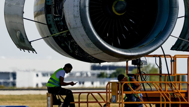 Arbeiter unter einer Turbine des ukrainischen Frachtflugzeugs „Antonow“
