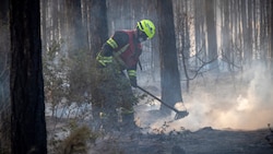 Noch immer sind die Feuerwehrleute mit dem Löschen von Glutnestern beschäftigt – auch die ganze ...