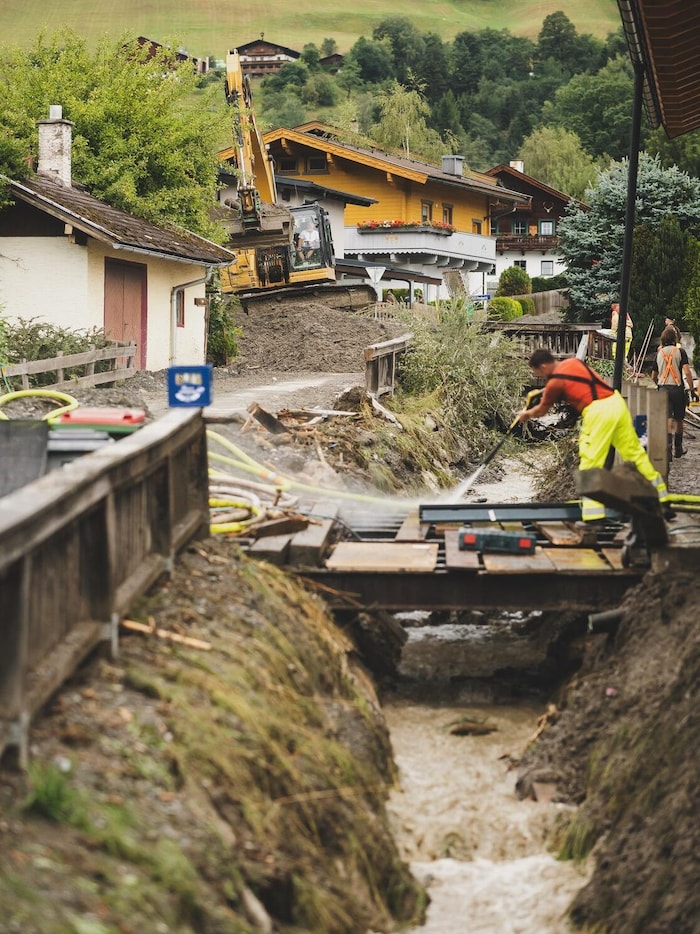 Mit Bagger und Schaufeln wird nach dem Unwetter in Stuhlfelden aufgeräumt.