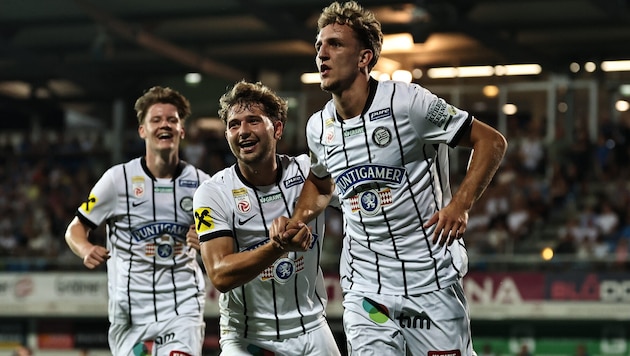 Nelson Weiper, who scored twice, is celebrated by his Sturm Graz teammates ...