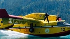 Ein Löschflugzeug holt am Montag Wasser aus dem Weißensee