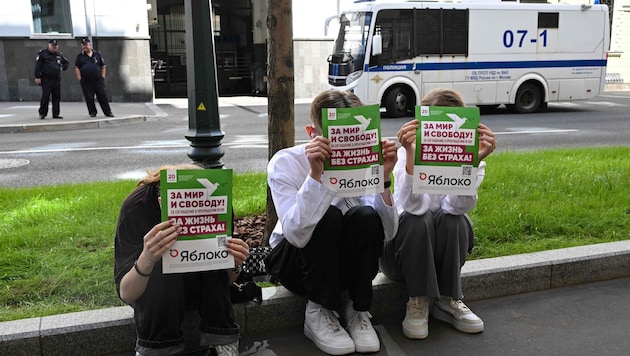 Unterstützer der liberalen Partei halten Plakate mit der Aufschrift „Für Frieden und Freiheit! ...