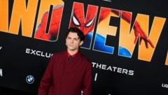 Hauptdarsteller Tom Holland vor einem offiziellen Spider-Man-Plakat