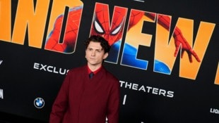 Hauptdarsteller Tom Holland vor einem offiziellen Spider-Man-Plakat