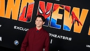 Hauptdarsteller Tom Holland vor einem offiziellen Spider-Man-Plakat