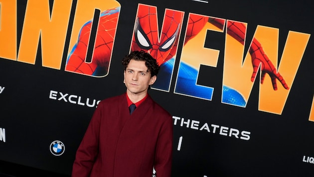 Hauptdarsteller Tom Holland vor einem offiziellen Spider-Man-Plakat