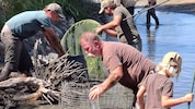Die Jäger halfen zusammen und holten die Fische aus dem seichten Wasser. 