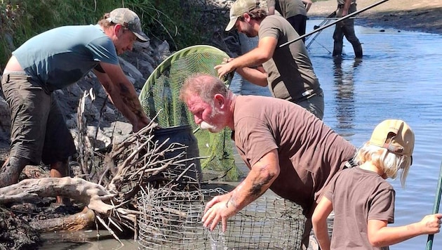 Die Jäger halfen zusammen und holten die Fische aus dem seichten Wasser.
