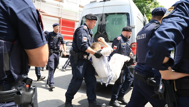 Eine Teilnehmerin im weißen Overall ließ sich von der Polizei wegtragen.