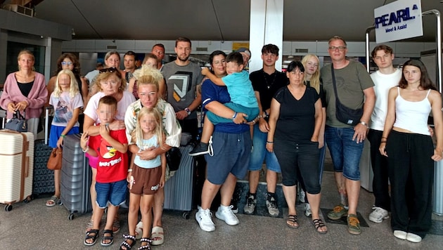 Einige der erschöpften und nach der langen Wartezeit verzweifelten Urlauber, die am Airport in ...