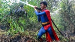 Der als Superman verkleidete Jugendliche bekämpft als freiwilliger Helfer die Flammen. 