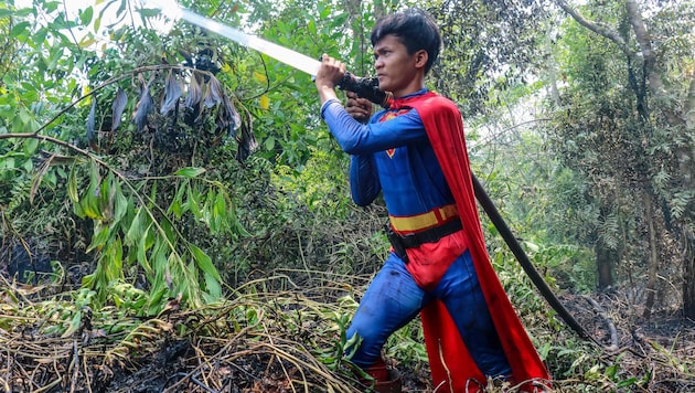 Der als Superman verkleidete Jugendliche bekämpft als freiwilliger Helfer die Flammen.