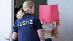 die Angeklagte Gina H. versteckt vor Gericht ihr Gesicht hinter einer Mappe. 