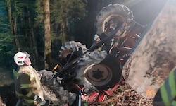 Der Traktor blieb in einem steilen Waldstück auf dem Dach liegen.