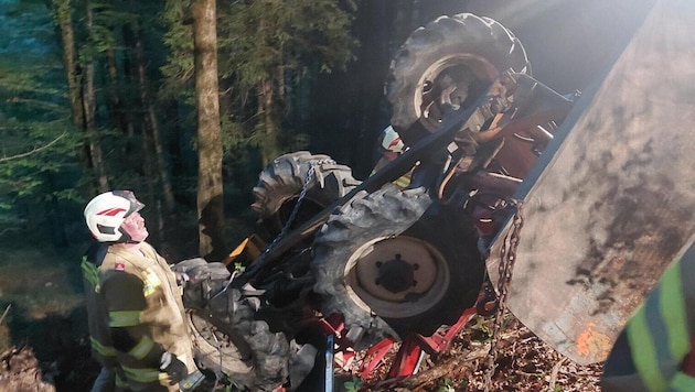 Der Traktor blieb in einem steilen Waldstück auf dem Dach liegen.