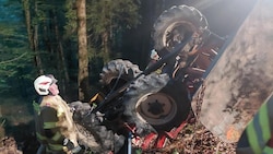 Der Traktor blieb in einem steilen Waldstück auf dem Dach liegen.