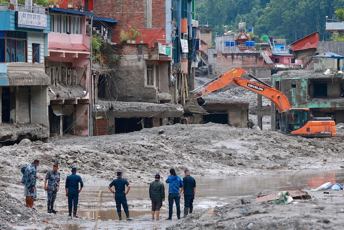 In Nepal kämpft man sich auf der Suche nach Vermissten durch die Schlammmassen.