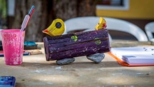 Kinder haben farbenfrohe Holz-Enten gestaltet, die sich am Mühlbach ein Rennen liefern – der ...