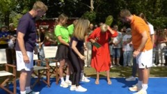 Moderatorin Andrea Kiewel versucht, das Insekt aus ihrem roten Kleid zu verjagen.  