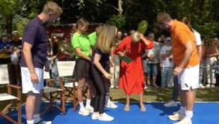 Moderatorin Andrea Kiewel versucht, das Insekt aus ihrem roten Kleid zu verjagen.  
