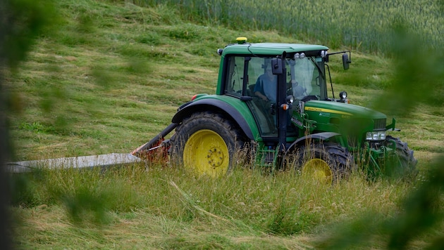 Traktor mit Mähwerk als Anhänger (Symbolfoto).