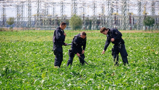 Polizisten suchen beim Umspannwerk Bergheim ein Feld ab. Dort kam es am Dienstag zu einem ...