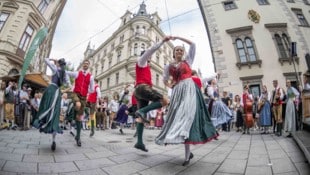 Musikalische Gruppen fordern in der ganzen Stadt zum Tanzen auf.