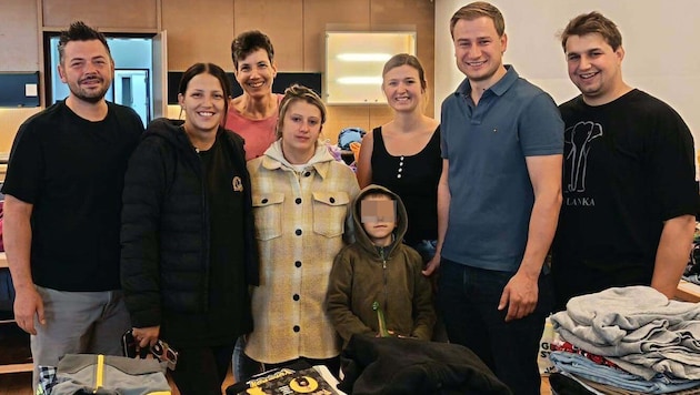 Der jüngste Sohn und die Mutter (Mitte) der betroffenen Familie mit Bürgermeister Kienzl (2. v. ...