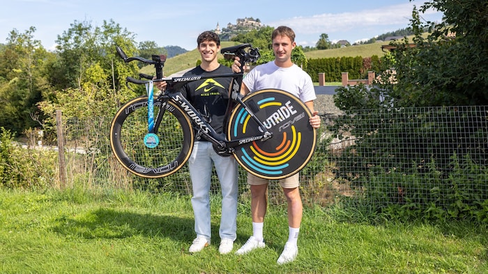 Rene und Andreas mit Rennrad und Medaille.
