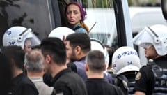 Eine der verhafteten Personen wird in einen Polizeibus eskortiert.