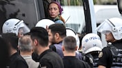 Eine der verhafteten Personen wird in einen Polizeibus eskortiert.