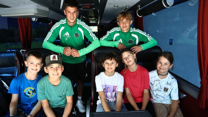Luis Gstrein (links) und Christopher Weinzierl mit Kids im Mannschaftsbus.