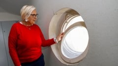 Angela Steiner zeigt ein Stiegenhaus-Fenster, das mittels alter Strumpfhose geschlossen wird.