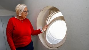Angela Steiner zeigt ein Stiegenhaus-Fenster, das mittels alter Strumpfhose geschlossen wird.