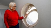 Angela Steiner zeigt ein Stiegenhaus-Fenster, das mittels alter Strumpfhose geschlossen wird.