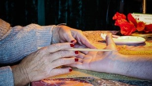 Linie für Linie: Monica Traber zeigt auf die Handfläche eines Besuchers und erklärt, was sie ...