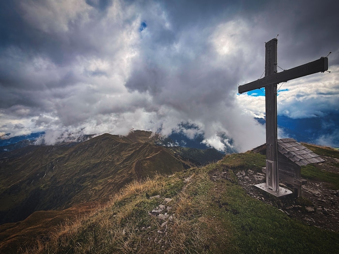 Das Gipfelkreuz steht nur wenige Meter neben der Schutzhüttentür.