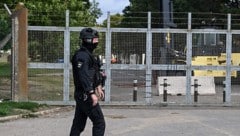 Ein schwer bewaffneter Polizist vor dem verriegelten Einfahrtstor der Basis RAF Fairford 