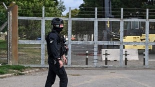 Ein schwer bewaffneter Polizist vor dem verriegelten Einfahrtstor der Basis RAF Fairford 