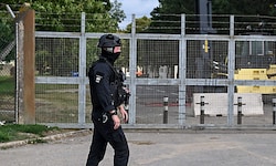 Ein schwer bewaffneter Polizist vor dem verriegelten Einfahrtstor der Basis RAF Fairford